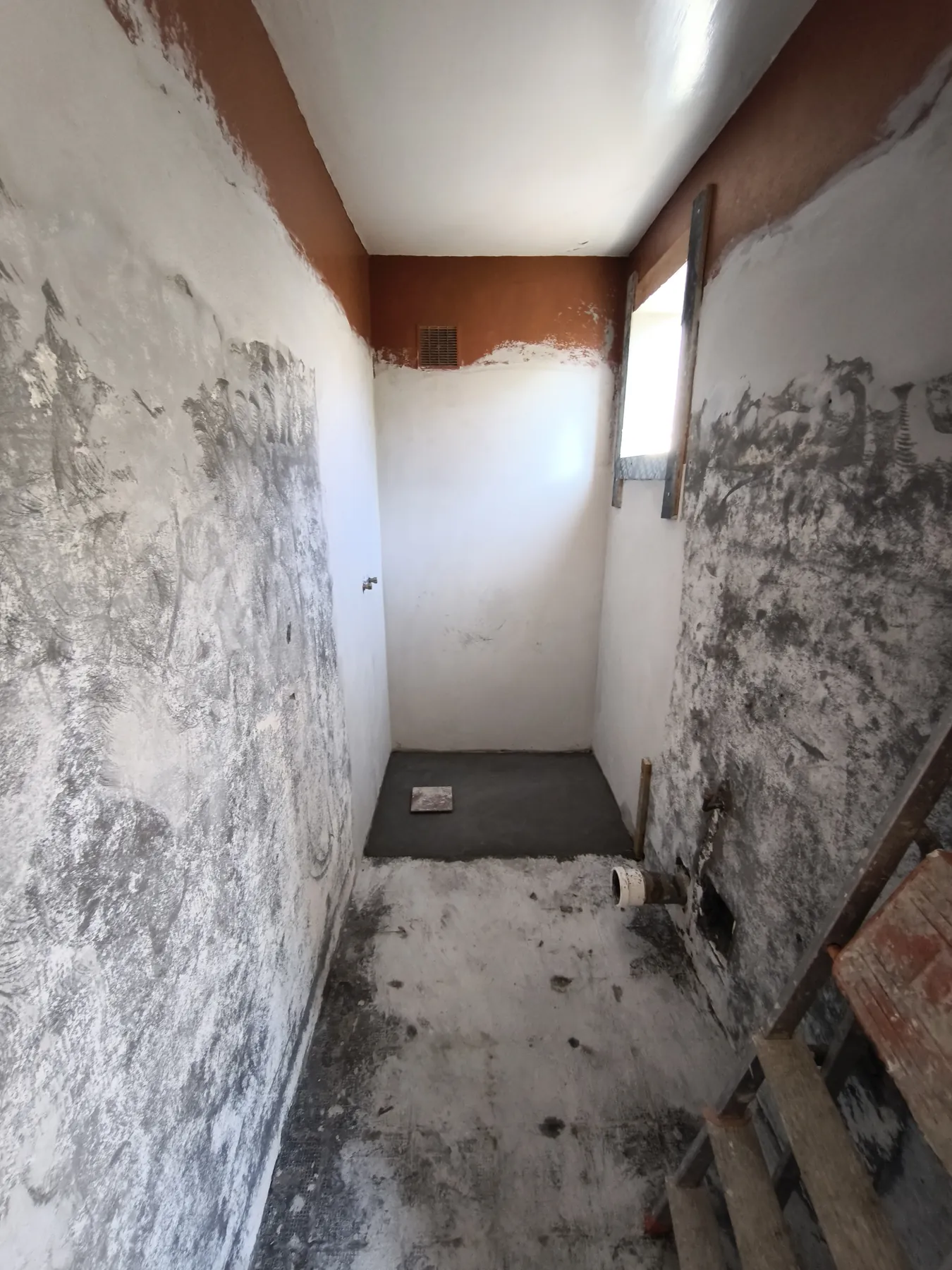 Salle d'eau avant travaux : murs décroûtés, sol déposé
